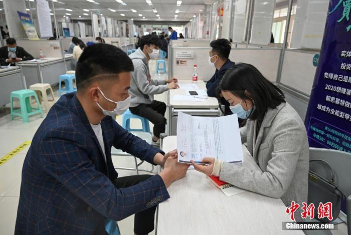 4月14日，招聘者在查看求職者簡歷。<a target='_blank'  data-cke-saved- >中新社</a>記者 王剛 攝
