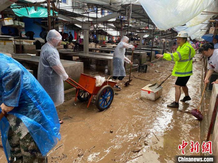 圖為7月26日，暴雨引發(fā)的洪水過境后，重慶萬州區(qū)分水鎮(zhèn)政府干部職工及志愿者清掃淤泥和垃圾?！　≈貞c萬州區(qū)委宣傳部供圖 攝
