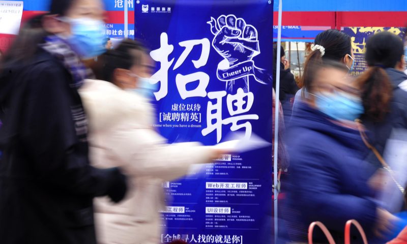 求職者從一家招聘企業(yè)的廣告牌前走過。新華社發(fā)（苑立偉 攝）